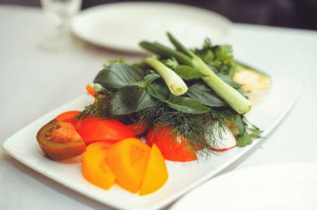 Fresh vegetable salad with radish, cucumber, bell pepper, tomatoes and herbs in a ceramic bowl restaurant dish. Selective focus.の写真素材