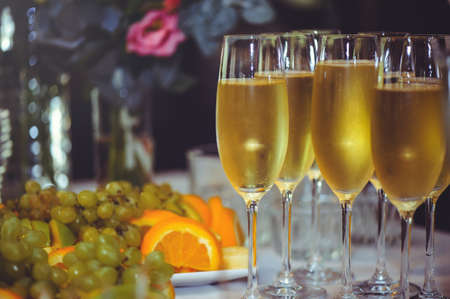 Buffet. The dining room is full of glasses of sparkling white wine with canapes and antipasti in the background. Champagne bubbles.の写真素材