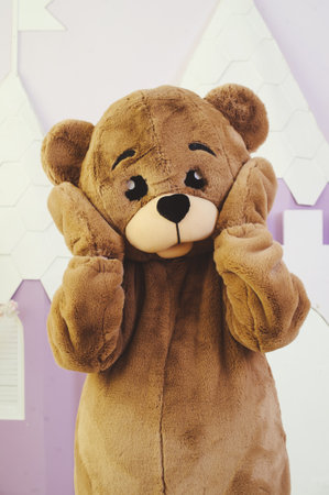 bear costume for holiday celebrations, entertainment for children and adults, holding his headの写真素材