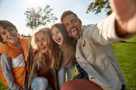 Proud to have a family. Happy family taking selfies outdoors