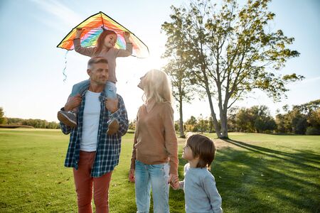 Loving atmosphere. Happy family playing a kite. Outdoor family weekendの写真素材