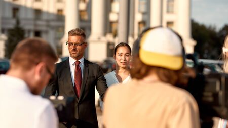 Be part of it. Cameraman recording interview of businesspeople. Journalism industry, live streaming concept.の写真素材