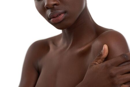Dark skin model. Cropped photo of african woman standing against white background. Beauty conceptの写真素材