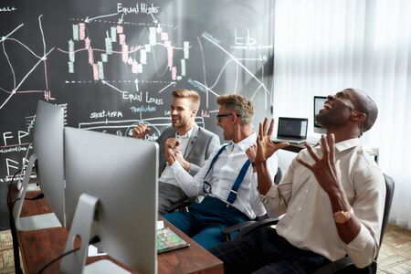 We did it. Three stock traders are happy with the results while looking at graphs, indexes and...