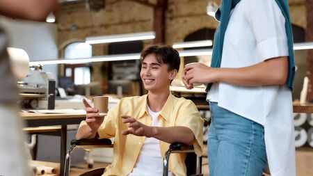 In choosing a partner, always pick the optimist. Guy in a wheelchair working in the officeの写真素材