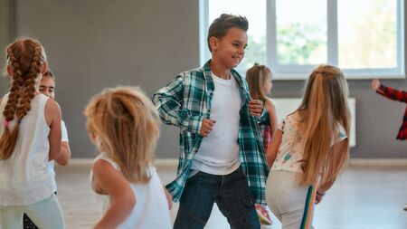 Having fun. Group of positive children learning a modern dance in the dance studio. Choreography conceptの写真素材