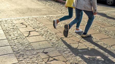 We should be there in time. Cropped photo of a couple in casual clothes running across the street. Walking together. Web banner. Crosswalkの写真素材