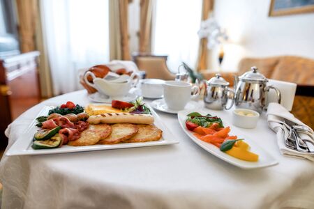 Luxurious Room Service. Close up of breakfast in luxury hotel room delivered by waiter. Hospitality and vacation conceptの写真素材