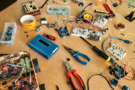 Robot diy assembly kit. Electrical components kit for building digital devices. Robotics parts and elements lying on a wooden desk. Electronics module setの写真素材