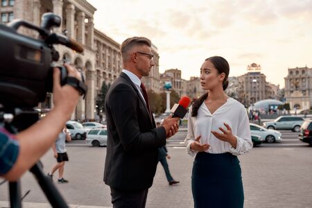 Professional reporter interviewing woman on urban street. Journalism industry, live streaming conceptの写真素材
