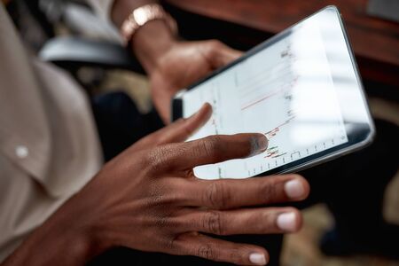 Nurture the future. Close up shot of hands holding tablet pc. Trader is using touch screen tablet...