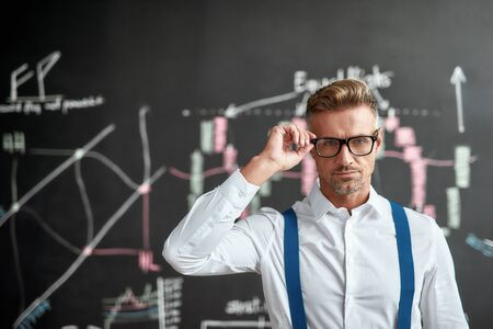 Make the intelligent move today. Close up of middle-aged employee, trader looking at camera and...
