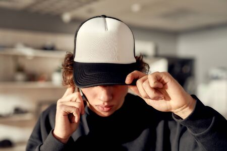 As individual as you. Stylish guy looking down while posing in custom apparel, black baseball cap...