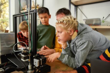 Innovation and Excellence. Caucasian girl is learning about working principle of 3d printer from her...