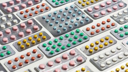 Composition with many medical pills, tablets pack in blister lying diagonally over white background. Health care, vitamins and treatment conceptの写真素材