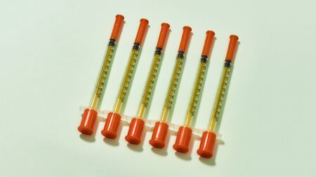 Top view of insulin syringes for diabetes lying isolated over light background. Injection medicine...