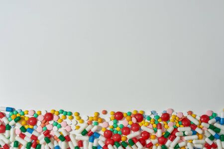 Different pills, capsules scattered horizontally over white background. Health care, vitamins and...