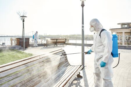 Keeping the city safe. Sanitization, cleaning and disinfection of the city due to the emergence of the Covid19 virus. Specialized team in protective suits and masks at workの写真素材