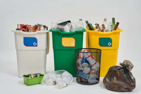 Set of three colorful green, yellow and white recycle garbage bins with recycle sign on it full of rubbish with other types of contaners isolated on white background. Waste separation conceptの写真素材