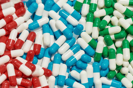 Close up of different pills, capsules lying randomly. Health care, vitamins and treatment concept