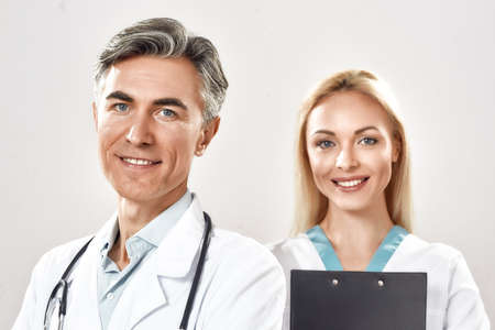 Portrait of two happy male and female doctors in medical uniform looking at camera and smiling. Strong medical team working together in a hospitalの写真素材