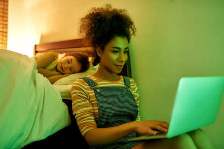Things to do. African american woman baby sitter spending time with little girl in the evening....