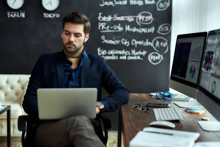 Analyzing statistical data. Portrait of a young concentrated businessman, financial analyst or sales...