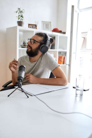 Male blogger, man in headphones talking to interlocutor while recording conversation, interview for video blogの写真素材