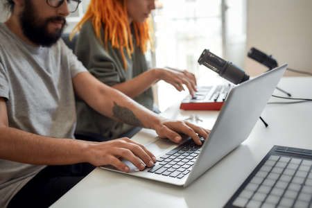Cropped shot of man using laptop. Female and male blogger preparing for filming, recording video...