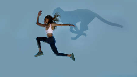 Wild. Full length shot of young sportive mixed race woman looking focused while jumping, running...