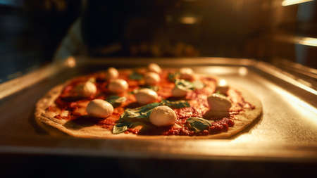 Close up shot of home made pizza margherita baking in the oven. Cooking at home conceptの写真素材