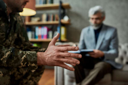 Recover. Cropped shot of middle aged military man during therapy session with psychologist. Soldier...