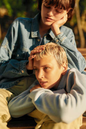 Cropped shot of two young girls relaxing on the bench in the city park on a sunny day. Lesbian...
