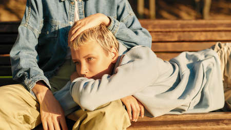 Cropped shot of two young girls relaxing on the bench in the city park on a sunny day. Lesbian...