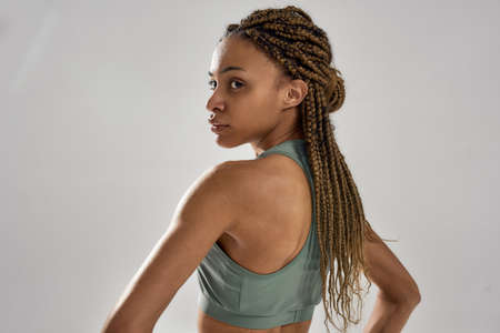 Fitness model. Portrait of a young attractive mixed race sportive woman in sportswear looking aside...