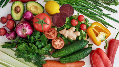 Top view of various colorful vegetables and herbs for making summer salad isolated over white...