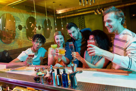 Making memories. Group of friends, young adults, men and women having fun while toasting, drinking...