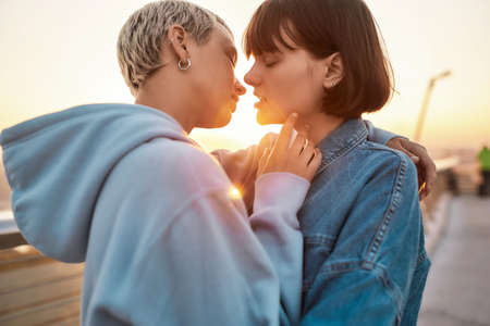 Young lesbian couple having romantic moment, Two women going to kiss while watching the sunrise together, Selective focusの写真素材