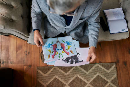 Top view of psychologist choosing picture with ink stain, Rorschach Inkblot during therapy sessionの写真素材