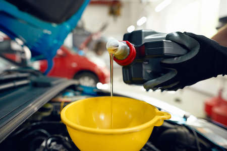 Engine oil from canister pouring in funnelの写真素材