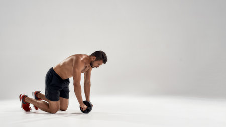 Young caucasian bodybuilder working with ab rollerの写真素材