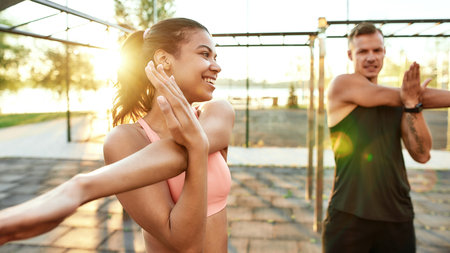 Mixed race girl training beside man on sport groundの写真素材