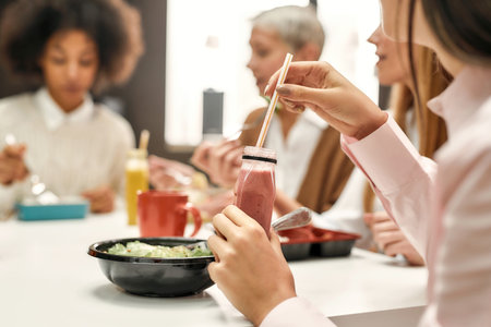 A close up of a healthy food with a smoothie drinking by a young woman sitting at a table during a...
