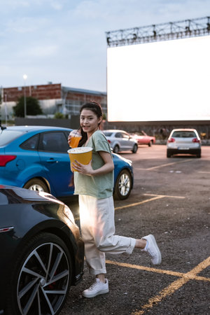 Smiling asian girl on car parking at auto cinema
