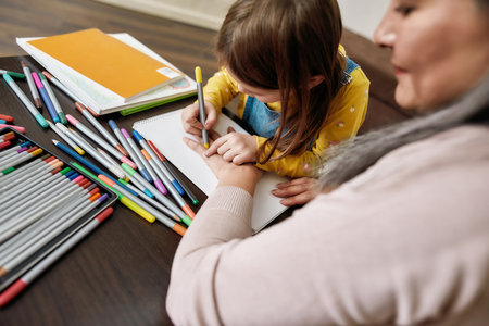 Cute little granddaughter drawing hand of grandmotherの写真素材