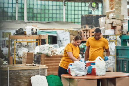 Man and woman checking litter on waste separation station