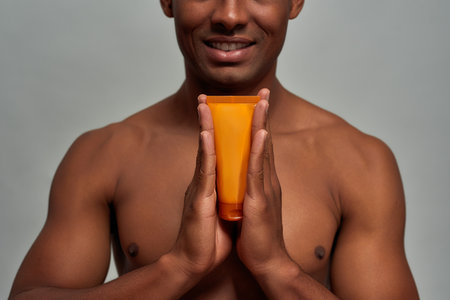 Smile on person face while holding a face care productの写真素材