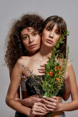 Female standing after her friend with bouquetの写真素材