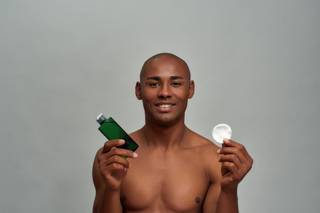 Adult man raising cotton pad and lotionの写真素材