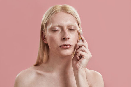 Young caucasian man massaging face with quartz roller